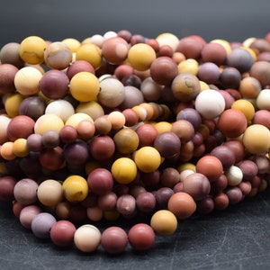 May include: A close-up of a pile of round, smooth, polished stones in various shades of brown, red, and yellow. The stones are arranged in a random pattern, creating a visually appealing and textured display.