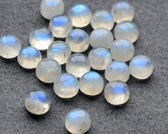 May include: A collection of round, iridescent moonstone cabochons in various sizes. The stones are a milky white color with a blue sheen.