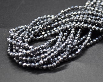 May include: A strand of black faceted glass beads. The beads are small and have a shiny finish.