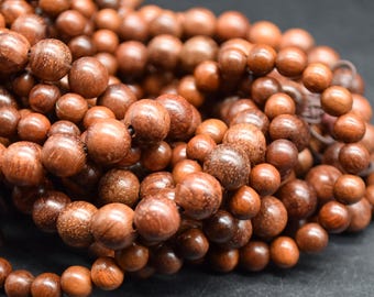 May include: A close-up of a strand of brown wooden beads. The beads are round and have a smooth, polished finish.
