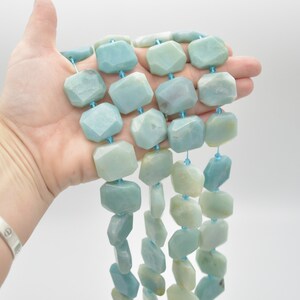 May include: A strand of light blue, faceted, amazonite beads. The beads are strung on a thin, light blue cord.