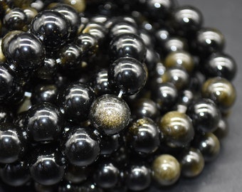 May include: A strand of black and gold beads. The beads are round and have a shiny, polished finish. The gold beads have a subtle sparkle.