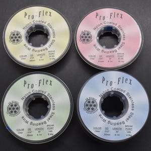 May include: Four spools of Pro-Flex nylon coated stainless steel beading wire. Each spool is a different colour: yellow, pink, green, and blue. The spools are labelled with the wire's colour, diameter, length, and break point.