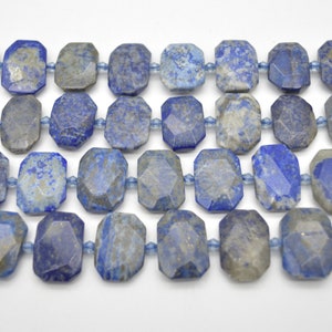 May include: A strand of faceted lapis lazuli beads. The beads are a deep blue with white and gold flecks. The beads are strung on a clear elastic cord.