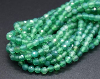 May include: A strand of green agate beads with a faceted finish. The beads are round and have a translucent appearance.