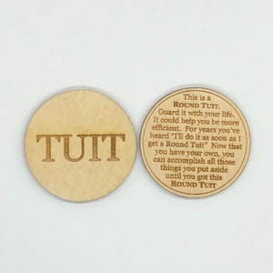 May include: Two wooden round tokens with the word "TUIT" engraved on one and the text "This is a ROUND TUIT. Guard it with your life. It could help you be more efficient. For years you've heard "I'll do it as soon as I get a Round Tuit" Now that you have your own, you can accomplish all those things you put aside until you got this ROUND TUIT" on the other.