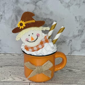 May include: A set of three ceramic mugs with a speckled, matte finish. The mugs are in shades of cream, light gray, and dark gray. Each mug has a simple, minimalist design, perfect for coffee or tea.
