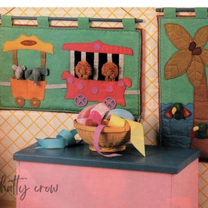 May include: Three felt wall hangings with a circus theme. The first features a red and yellow circus wagon with three stuffed animals inside. The second is a green palm tree with two birds. The third is a green background with the word "Circus" on a yellow sign.