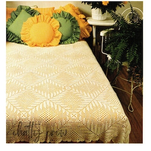 May include: A crocheted bedspread in a cream color with a geometric pattern. The bedspread is on a bed with yellow and green pillows.