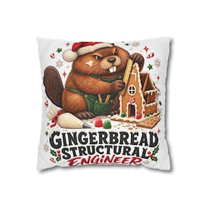 Könnte beinhalten: Ein weißes Dekokissen mit einem braunen Biber, der eine Weihnachtsmütze und eine grüne Latzhose trägt und ein Lebkuchenhaus mit einem gelben Lineal misst. Darunter steht der Text GINGERBREAD STRUCTURAL ENGINEER, umgeben von weihnachtlichen Symbolen.