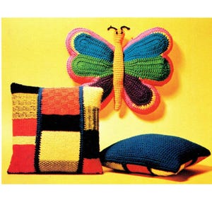 May include: Three colorful crocheted pillows, one shaped like a butterfly, one with a geometric pattern, and one with a solid blue color.