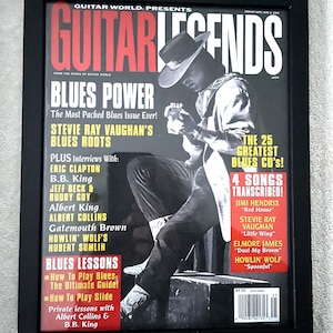 May include: Framed Guitar Legends magazine cover featuring Stevie Ray Vaughan playing guitar. The cover has a black and red color scheme with text that reads "Blues Power" and lists interviews with Eric Clapton, B.B. King, and others. The magazine is displayed in a black frame.
