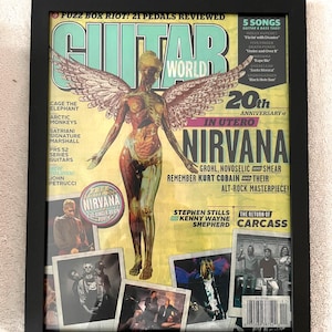May include: Framed Guitar World magazine cover featuring Nirvana's "In Utero" album art. The cover art depicts a nude figure with wings. The magazine's title is in large, turquoise letters. Additional text includes band names and album details.