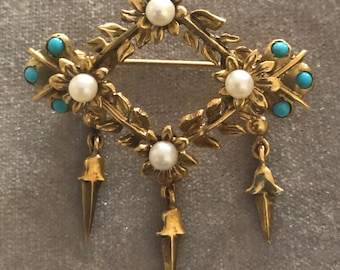May include: A gold brooch with a diamond-shaped design featuring four pearl-centered flowers and turquoise accents. Three dangling spear-shaped pendants hang from the bottom.
