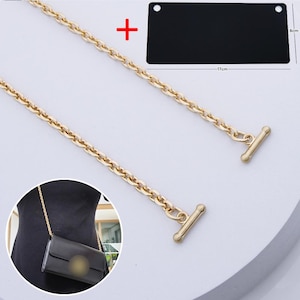 May include: A gold-toned metal chain strap featuring two T-bar toggles at the ends. A black rectangular bag component is shown with dimensions of 17 cm by 8 cm. The chain is displayed attached to a black bag in an inset circular image.