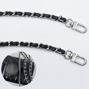 May include: A black leather strap interwoven with silver-toned metal chain links, featuring a swivel lobster clasp at each end. An inset shows a black quilted handbag with a circular clasp attached to this matching chain strap.
