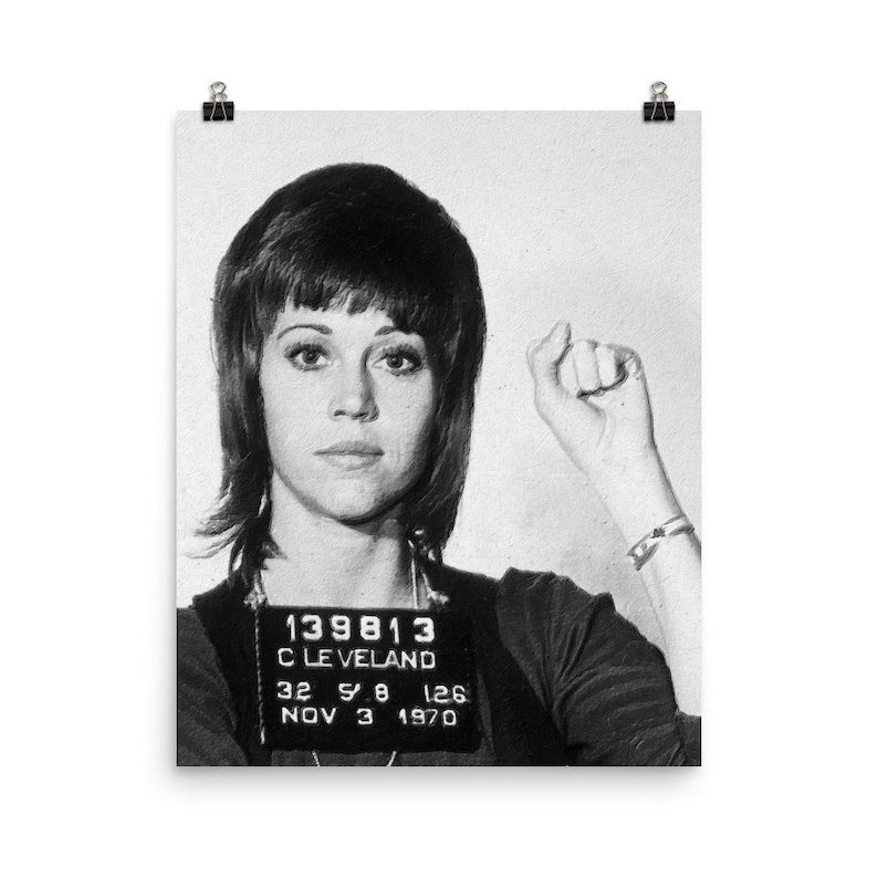 May include: Black and white mugshot photo of a woman with short, dark hair. She is wearing a dark shirt and has a name tag that reads "139813 CLEVELAND 32 5'8 126 NOV 3 1970".
