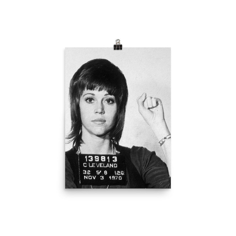 May include: Black and white mugshot photo of a woman with short, dark hair. The photo shows the woman's face and shoulders. The photo includes a mugshot card with the text "139813 CLEVELAND 32 5'8 126 NOV 3 1970".