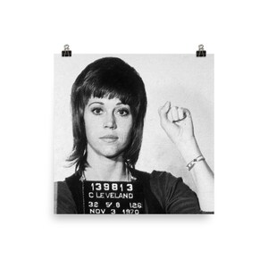 May include: Black and white mugshot photo of a woman with short, dark hair. The photo includes the text "139813", "CLEVELAND", "32 5 8 126", and "NOV 3 1970".