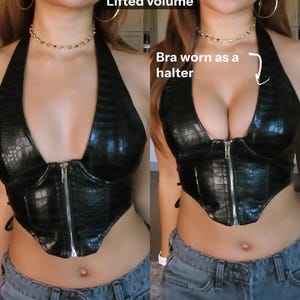 Puede incluir: Top halter negro con un patrón texturizado similar a la piel de reptil y cremallera frontal. Se combina con vaqueros azules. El texto "Lifted volume" y "Bra worn as a halter" es visible en la imagen.