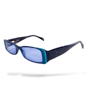 May include: Blue rectangular sunglasses with a dark navy frame and light blue lenses. The frames have a teal accent on the front and a decorative logo on the temples. The sunglasses are a stylish accessory.