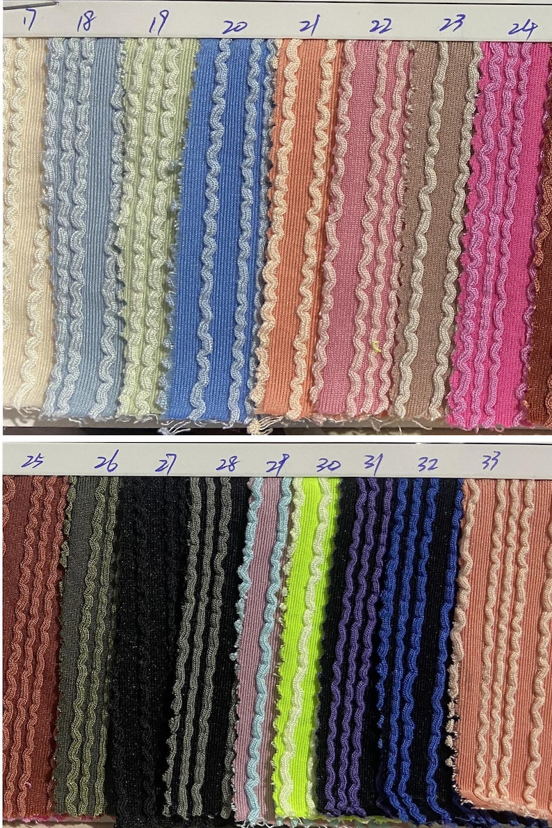 May include: A fabric swatch card featuring various colors of textured fabric with a wavy trim. Colors include beige, blue, green, orange, pink, brown, black, purple, and neon green. Numbers 17-33 are visible.