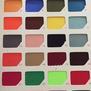 May include: A colour chart with 28 fabric swatches, numbered 1 through 28. The swatches are arranged in four rows of seven. The colours include black, white, blue, green, red, orange, yellow, brown, grey, pink, and purple.