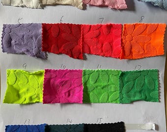 May include: A swatch card with 15 fabric samples in different colors and patterns. The fabric is textured with a leaf design. The swatches are numbered 1 through 15.