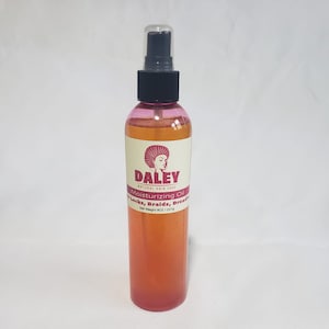 May include: A clear bottle with a pink label that says "DALEY NATURAL HAIR CARE Moisturizing Oil For Locks, Braids, Dreadlocks Net Weight 8OZ / 227g". The bottle has a black spray top.