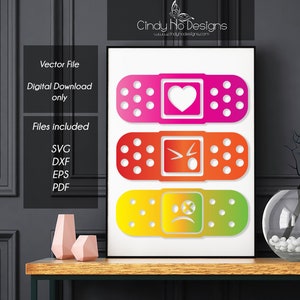 May include: A framed print featuring three colorful bandage designs. Each bandage has a different emoji: a heart, an angry face, and a sad face. The print includes the text "Vector File, Digital Download only, Files included: SVG, DXF, EPS, PDF."