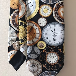 May include: A black necktie featuring a repeating pattern of antique clock faces in shades of gold, brown, and white. The clocks have Roman numerals and intricate details. The tie's design includes the text "CLOCKMAKER 1960".
