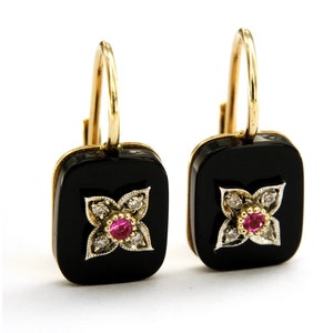Könnte beinhalten: Ein Paar goldene Ohrringe mit quadratischen Steinen aus schwarzem Onyx. Jeder Stein hat ein kleines Blumenmuster mit einem rosafarbenen Rubin in der Mitte und kleinen Diamanten darum herum.