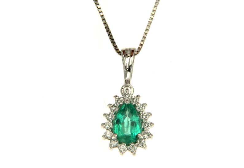 May include: A pear-shaped emerald gemstone pendant set in a silver chain. The emerald is surrounded by a halo of smaller diamonds.