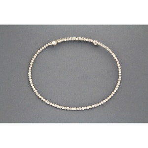 May include: A silver bracelet with a textured design and small round beads.