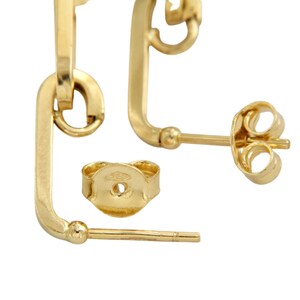May include: A pair of gold earrings with a simple, geometric design. The earrings are made of 14k gold and have a polished finish.