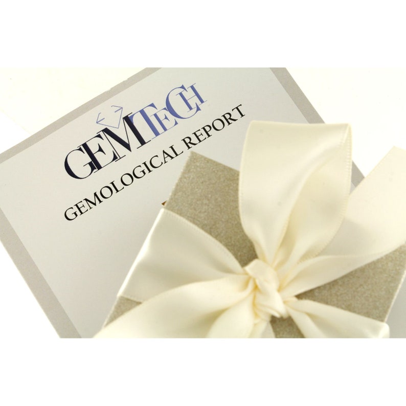May include: A white gift box with a white satin ribbon tied in a bow. The box is sitting on top of a white card with the text "GEMTECH GEMOLOGICAL REPORT".