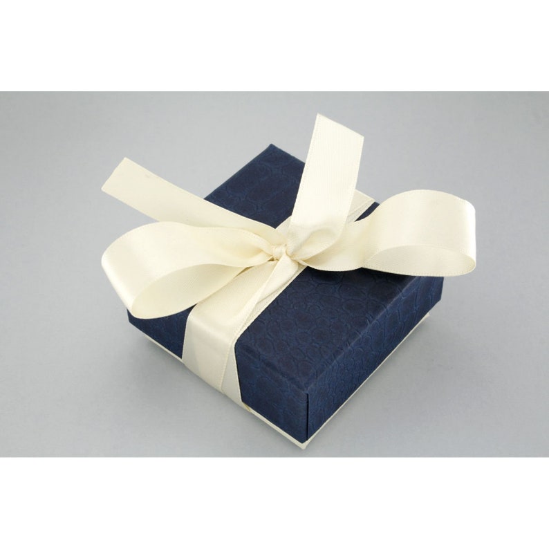 May include: A navy blue gift box with a white satin ribbon tied in a bow.