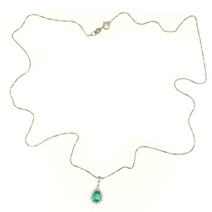 May include: A silver chain necklace with a pear-shaped emerald pendant surrounded by smaller diamonds.