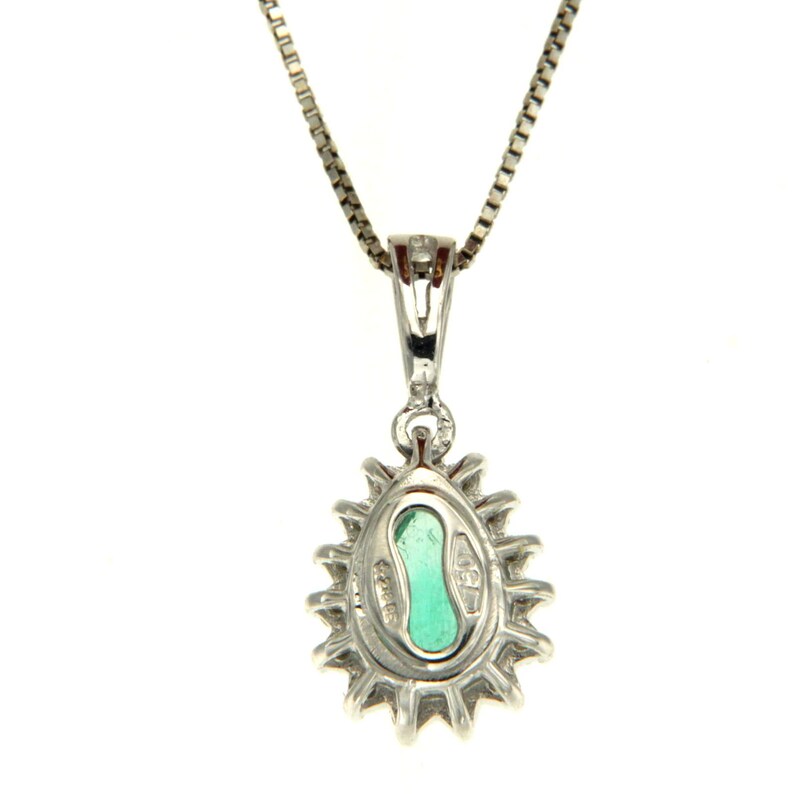 May include: A silver necklace with a pear-shaped green gemstone pendant surrounded by smaller diamonds. The pendant has a detailed design and is set in a silver halo.