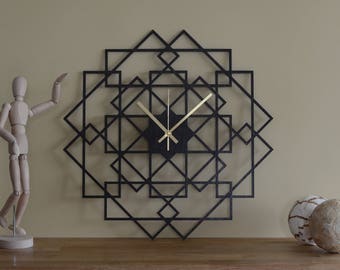 May include: Black geometric wall clock with gold hands. The clock is made of wood and has a modern design.