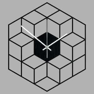 Könnte beinhalten: Eine geometrische Wanduhr in Schwarz und Weiß mit einem Holzgesicht und weißen Zeigern. Die Uhr ist würfelförmig und hat einen 3D-Effekt.