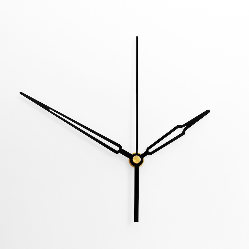 May include: Black clock hands with a gold center point against a white background.