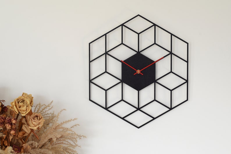 May include: A black geometric clock with red hands and a black face. The clock is shaped like a hexagon and is made up of a series of overlapping cubes.