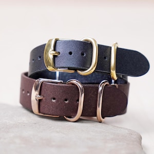 May include: Two leather watch straps, one brown and one black, with gold and rose gold buckles.