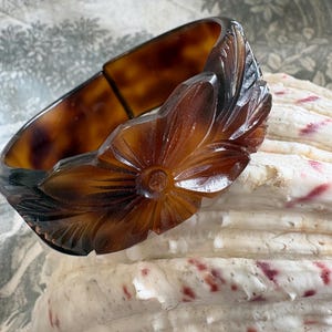 Brazalete ancho de celuloide vintage con efecto carey tallado, cierre floral articulado, estilo art déco, llamativo de la década de 1930.