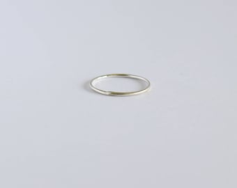 May include: A simple silver band ring.