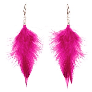 Può includere: Un paio di orecchini con piume rosa acceso. Ogni orecchino presenta un gruppo di piume rosa brillante, a forma di goccia, sospese a un gancio in metallo argentato. Le piume sono attaccate a un piccolo pezzo di metallo rettangolare.