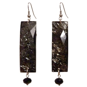 Peut inclure: Une paire de boucles d'oreilles pendantes argentées avec des pendentifs rectangulaires noirs et des accents de perles noires.