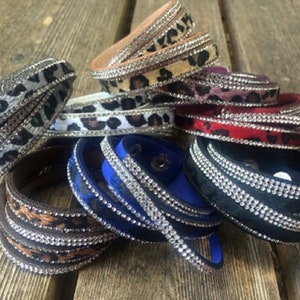 May include: A set of ten leopard print wrap bracelets with silver rhinestone accents. The bracelets are made of leather and are available in a variety of colors.