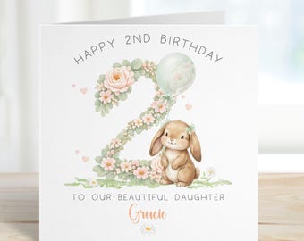 May include: A white birthday card with the text "HAPPY 2ND BIRTHDAY" and "TO OUR BEAUTIFUL DAUGHTER Gracie". The card features a floral "2" with a bunny and a balloon.